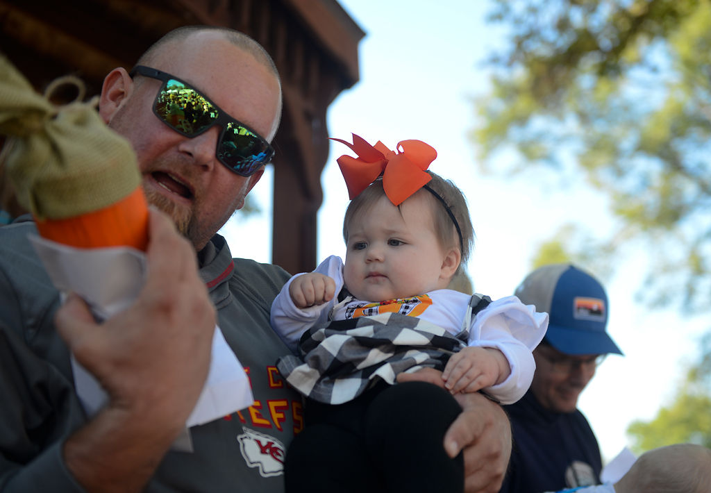 Jon Zimny, left, shows Georgia Noelle Zimny, 9 months old, the prize she won